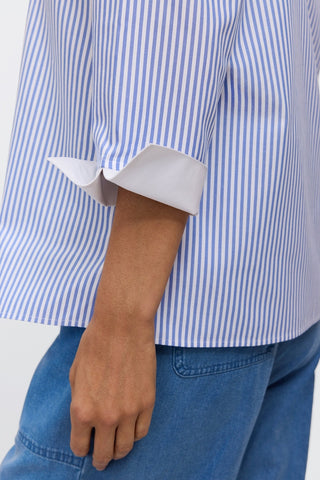 Close up side view of the 3/4 length sleeves and the white arm cuff folded #color_powder blue pinpoint stripe