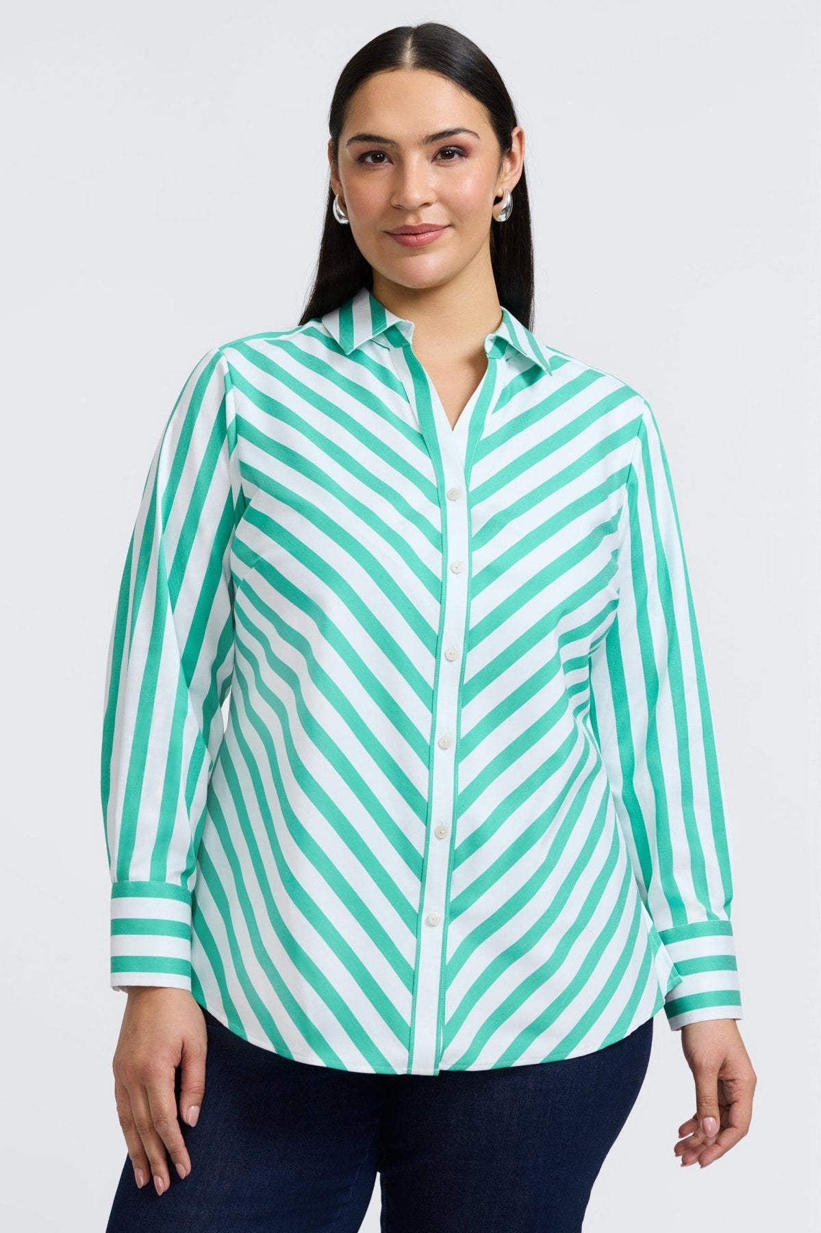 Plus-sized woman in a button down shirt with kelly green stripes, designed in a flattering fit that transitions from work to weekend.