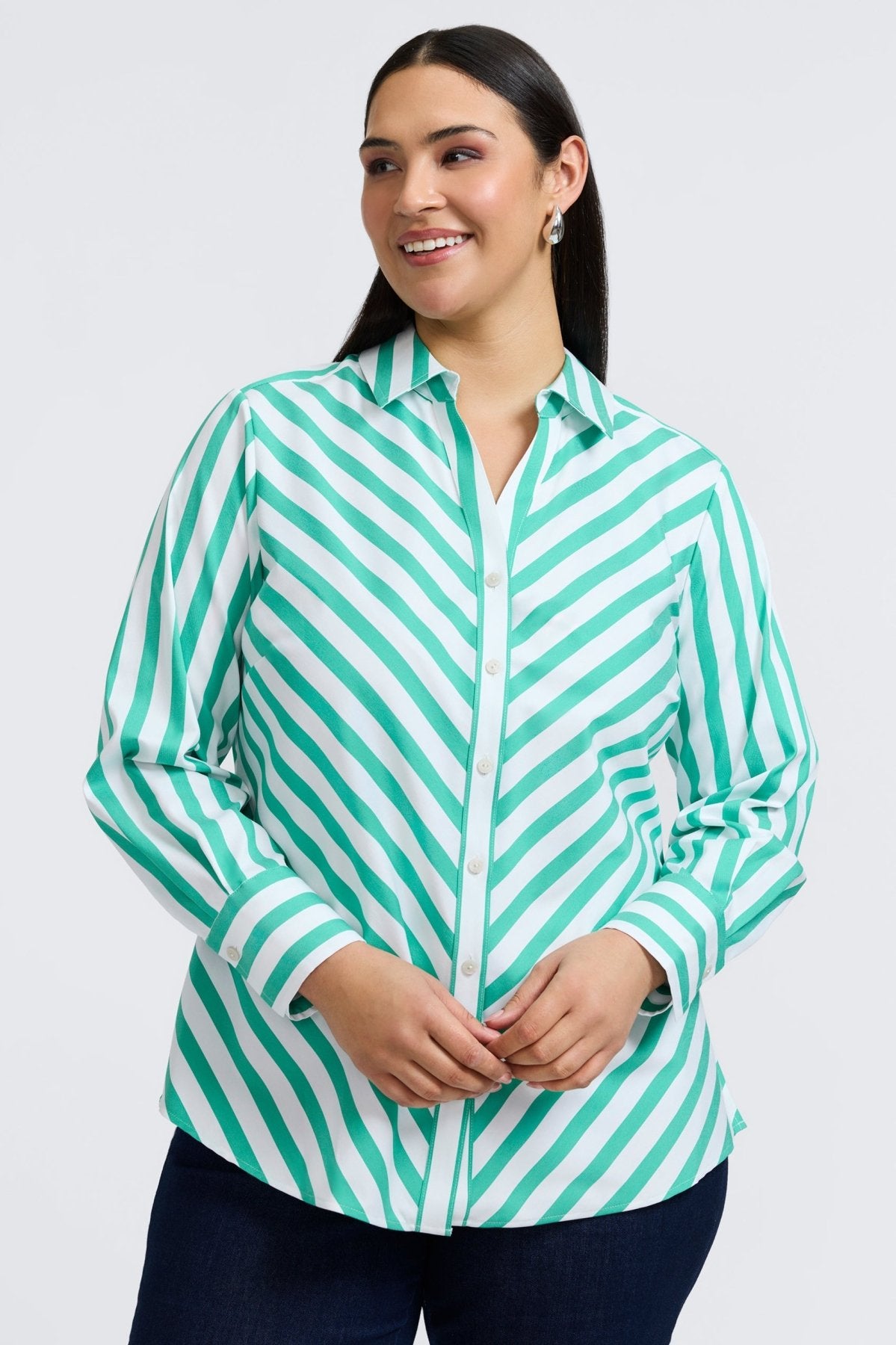 Plus-sized woman in a button down shirt with kelly green stripes, designed in a flattering fit that transitions from work to weekend.