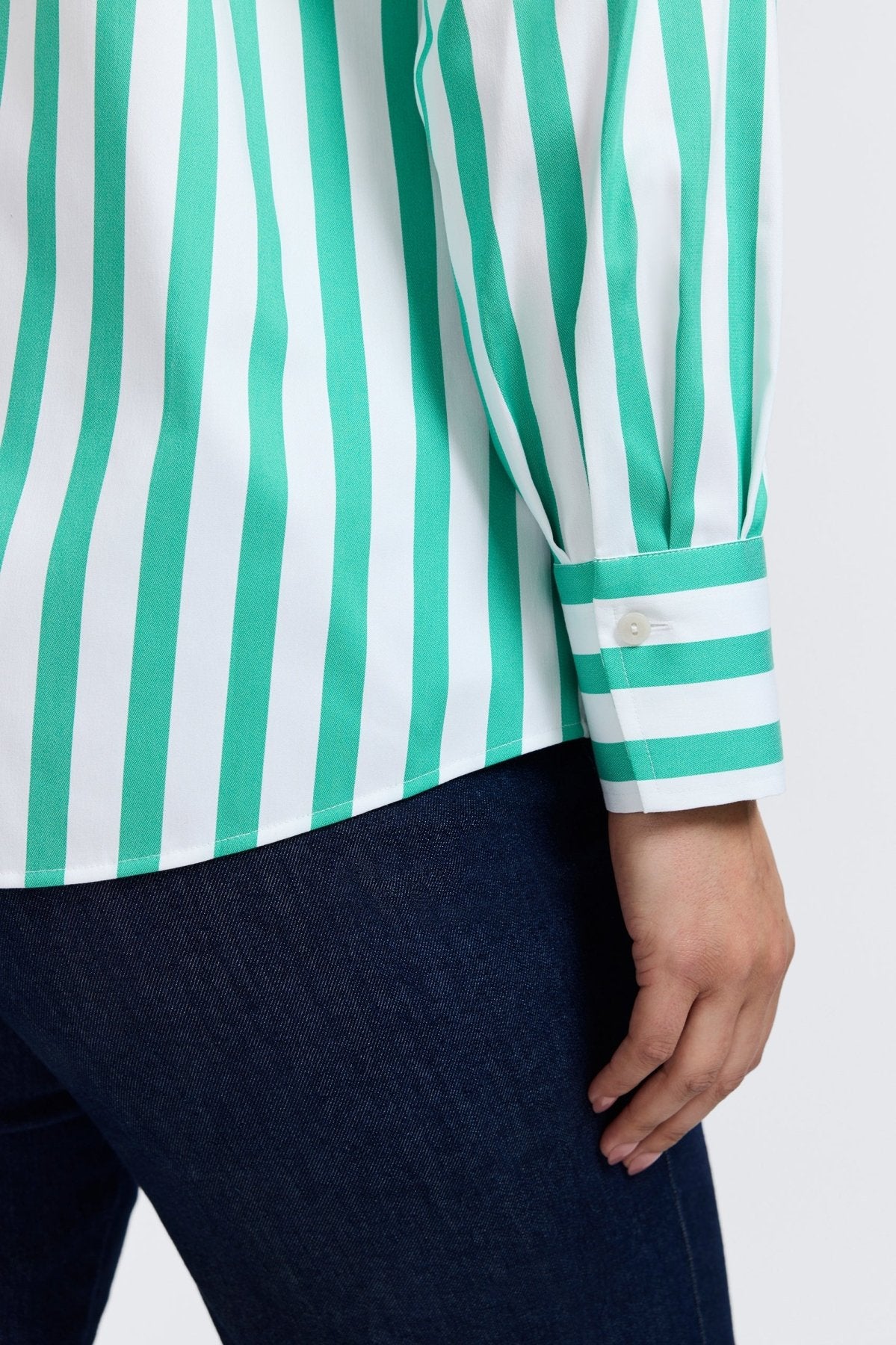 Plus-sized woman in a button down shirt with kelly green stripes, designed in a flattering fit that transitions from work to weekend.