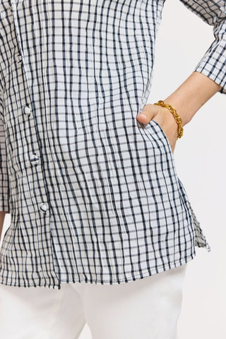 Close up of bottom half of the textured shirt with models hand in pocket #color_White/Black