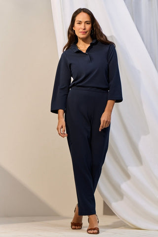 Front view of a woman wearing the Tammy Knit Crepe 3/4 Sleeve Popover Shirt tucked into her pants #color_navy