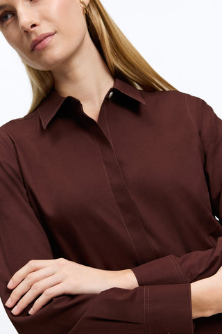 Close up a woman wearing the Cici No Iron Pinpoint Long Sleeve Tunic with her arms crossed in front of her #color_chicory coffee