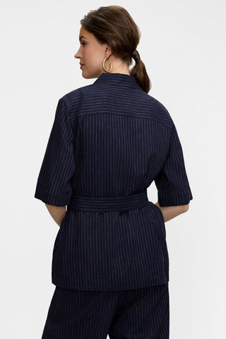Back view of the Estela Pinstripe Linen Short Sleeve Jacket worn with the self tied belt around the waist