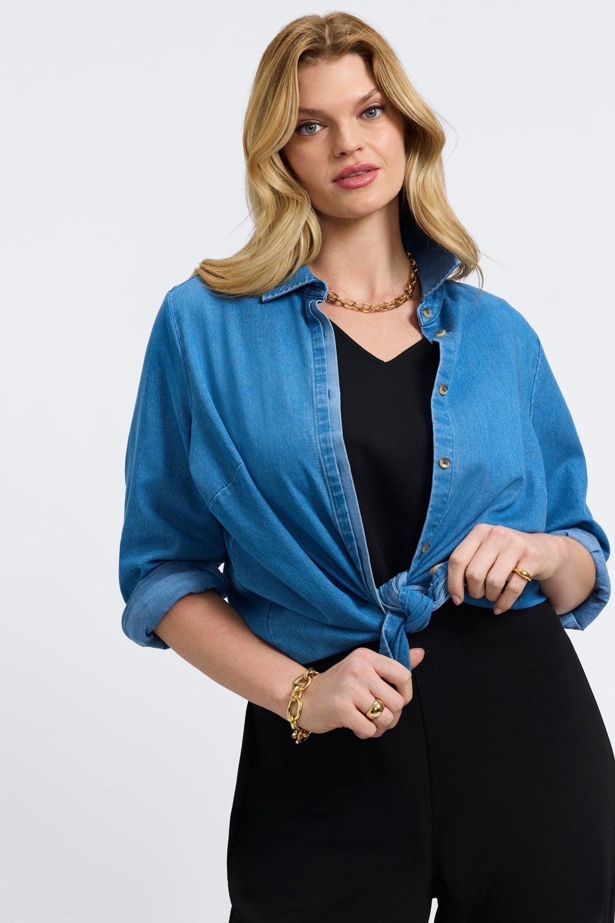 Woman in a medium denim button-front shirt from Foxcroft, designed with casual sophistication and lasting comfort.