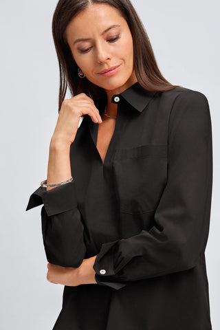 Close up view of a woman wearing the Bella No Iron Stretch Long Sleeve Shirt
showing the folded sleeves and open neck #color_black