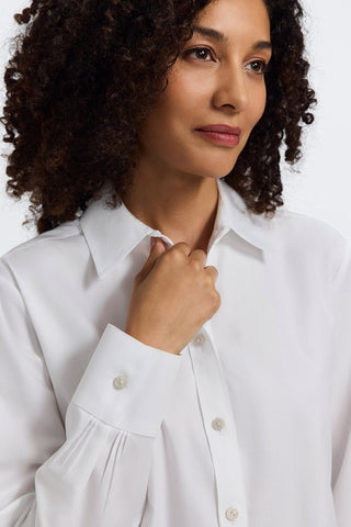 Close up of women wearing the Meghan No Iron Pinpoint Long Sleeve Shirt with her hand on the collar #color_white