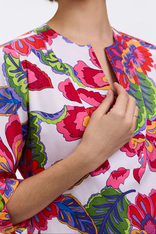 Woman wearing a colorful floral blouse with a white background