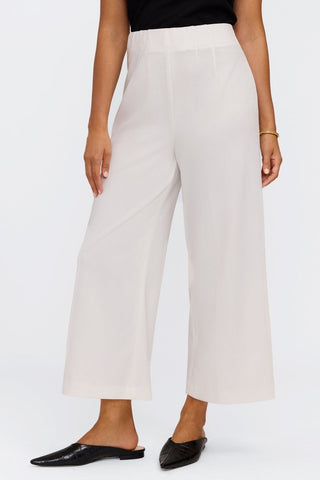 View of model with foot turned outward showing off the ankle hitting length of the wide leg pants #color_ecru