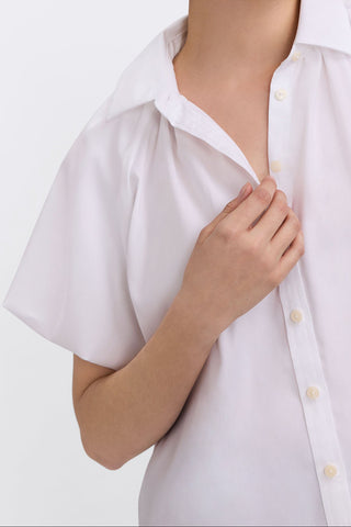 Angled close up featuring the puff sleeve and clean collar of the Paula Plus Solid Puff Sleeve Shirt #color_white