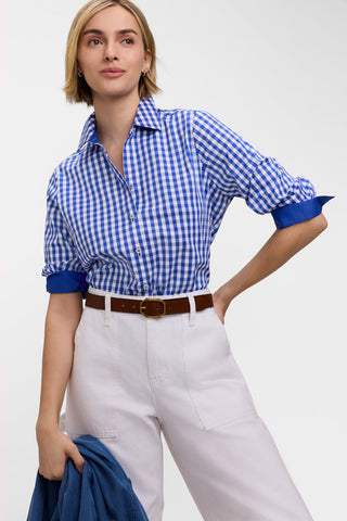 Model wearing the Margie Gingham Stretch Matte Sateen 3/4 Sleeve Shirt
tucked into her white pants with the cuffs folded back to reveal the plain contrasting fabric on the underside #color_deep sea/white gingham