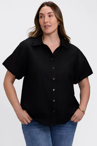 Front view of model wearing the Paula Plus Solid Puff Sleeve Shirt with her hands on her hips #color_black
