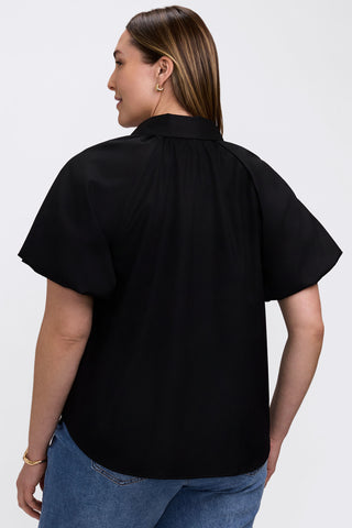 Back angle of model wearing the Paula Plus Solid Puff Sleeve Shirt #color_black