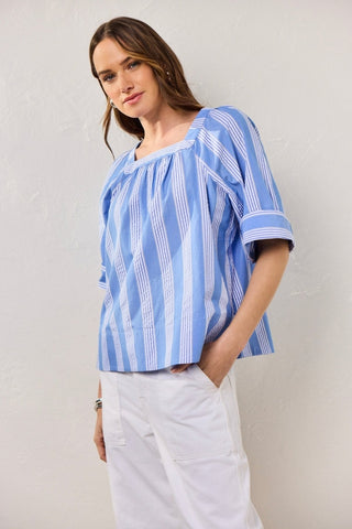 Plus-size model in a textured seersucker Blue shirt with soft white stripes, styled for breathable ease and polished charm.