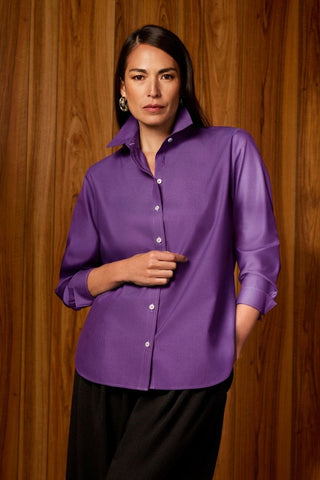 Woman in Meghan No Iron Pinpoint Long Sleeve Shirt with an unfolded collar and wooden background #color_royal purple