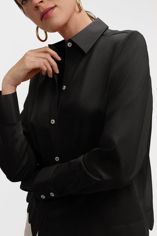 Angled front view of model wearing the Scarlett Stretch Matte Sateen Long Sleeve Shirt with one hand touching the collar #color_black