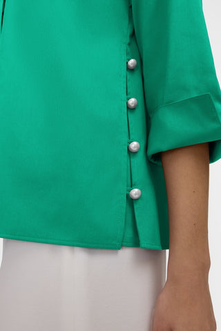 Close up of the full coverage side slit of the Beatrice Pearl Stretch Matte Sateen 3/4 Sleeve Shirt and it's pearl buttons #color_kelly green