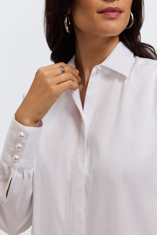 Close up of triple-button cuffs showing off stunning pearls, and a single standout pearl on the collar #color_white