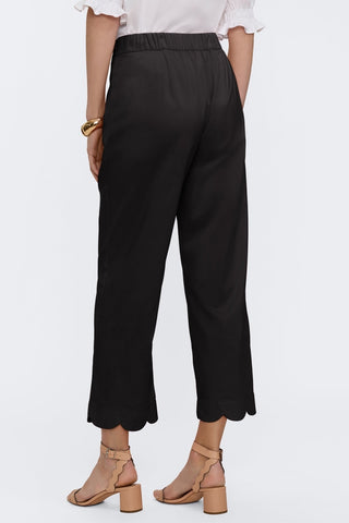 Angled back view of the satin matte capris #color_black