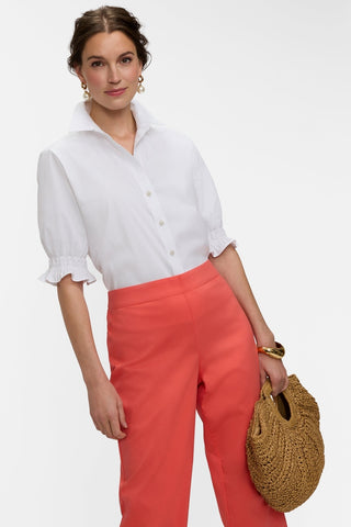 Angled view of model with hip popped wearing a shirt tucked into the matte capris #color_georgia peach