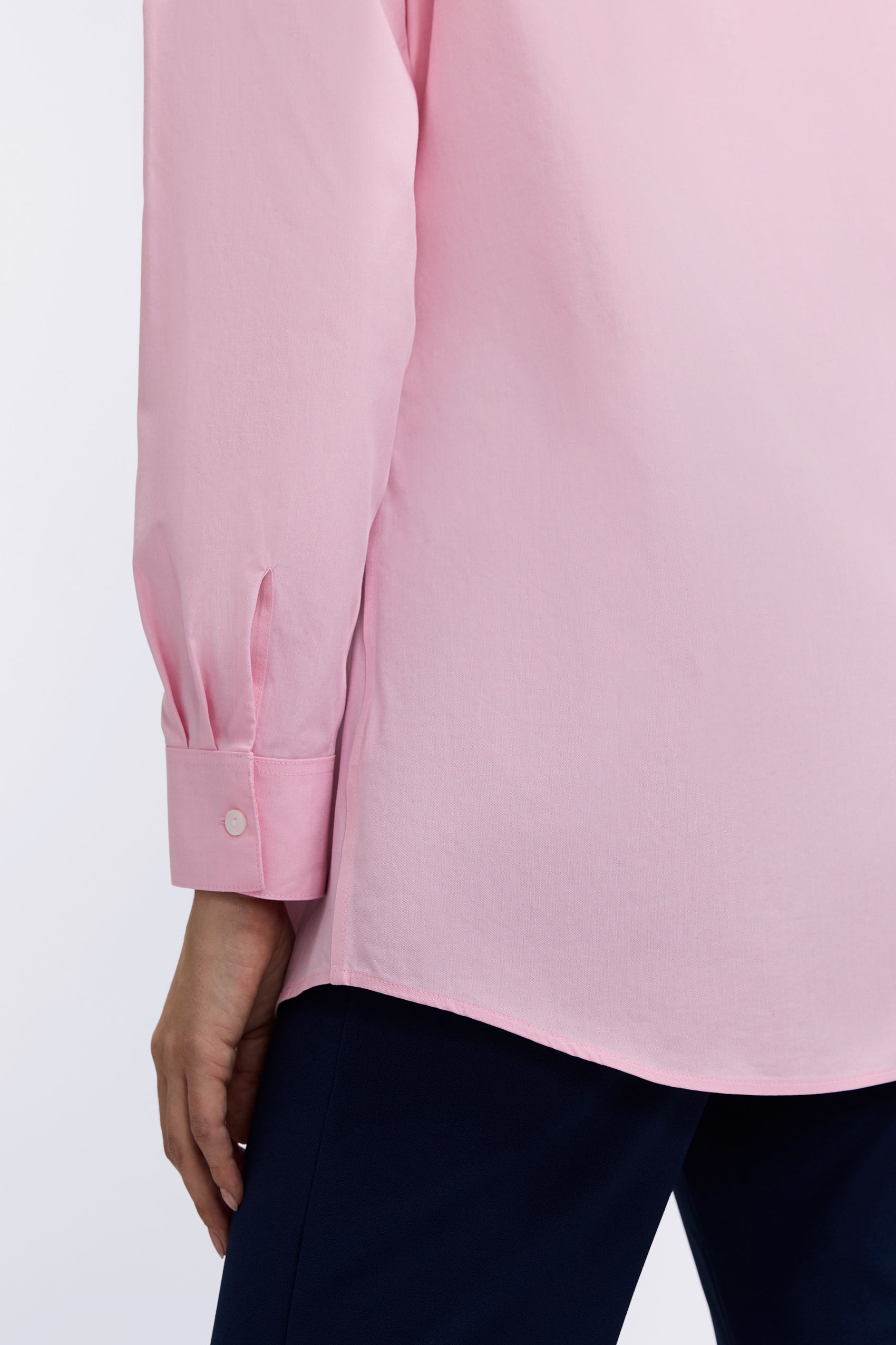 Back view of the Cici No Iron Pinpoint Long Sleeve Tunic showing the finished hem and the buttoned cuff #color_chambray pink