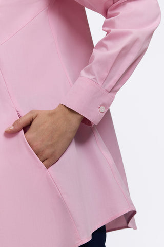 Close up of a hand in the angled pocket and the buttoned cuff of the sleeve on the Cici No Iron Pinpoint Long Sleeve Tunic #color_chambray pink