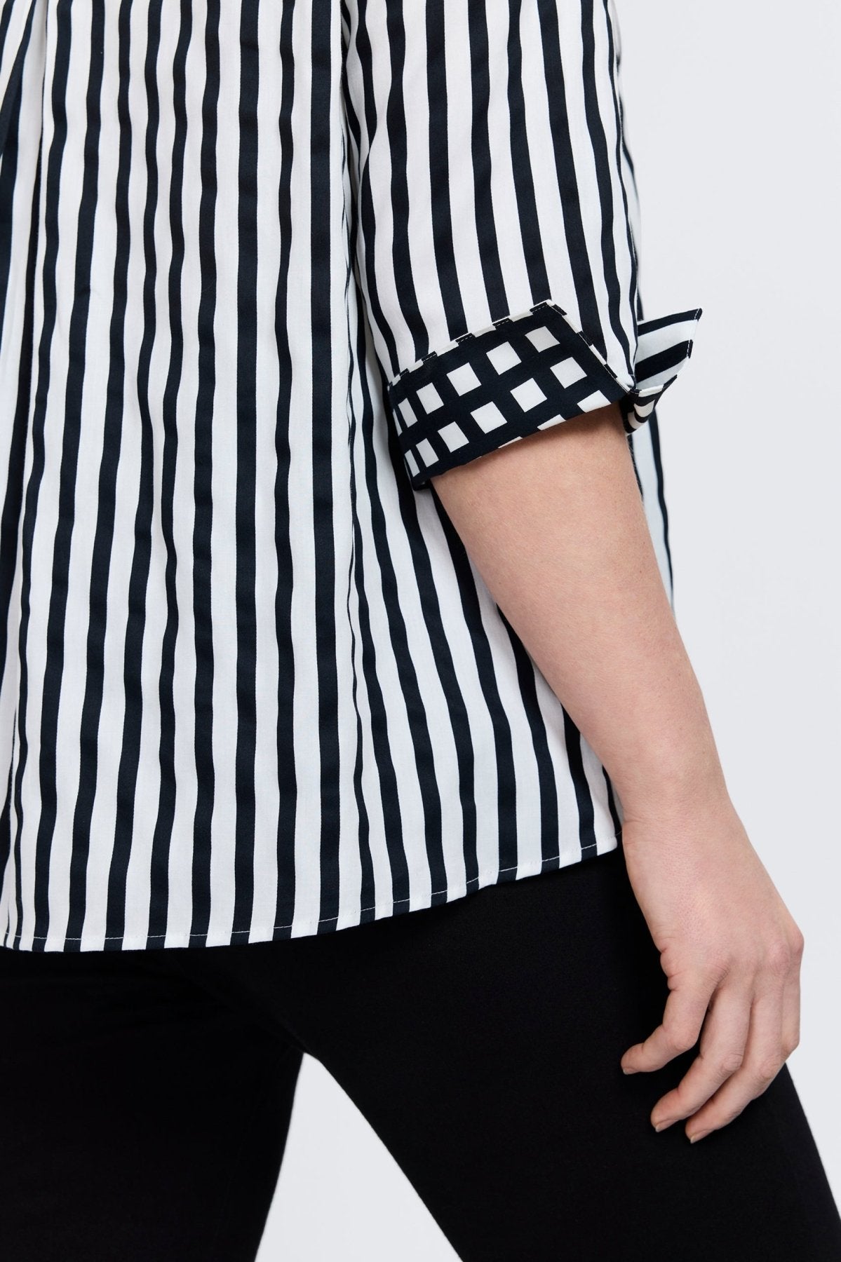 Agnes shirt with black stripes and gingham border, styled on a plus-size model for modern structure and classic charm.