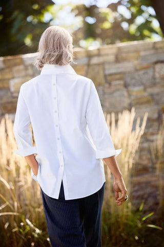 Therese 3/4 sleeve popover shirt in white worn by a woman outside facing away
