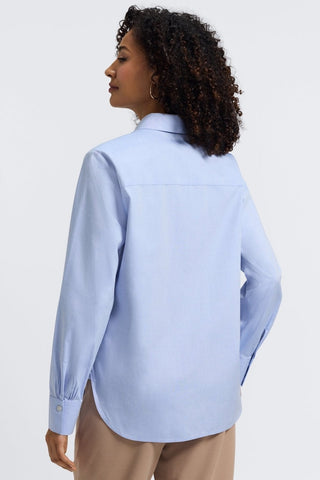 Angled back view of a woman wearing the Meghan No Iron Pinpoint Long Sleeve Shirt #color_blue wave