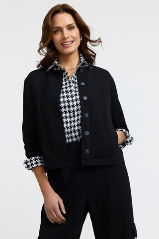 Front view of model wearing the Meghan Classic Houndstooth Long Sleeve Shirt
underneath a black jacket with sleeves folded out to show off the pattern 