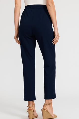 Angled back view of the form fitting sleek ankle length pants #color_navy
